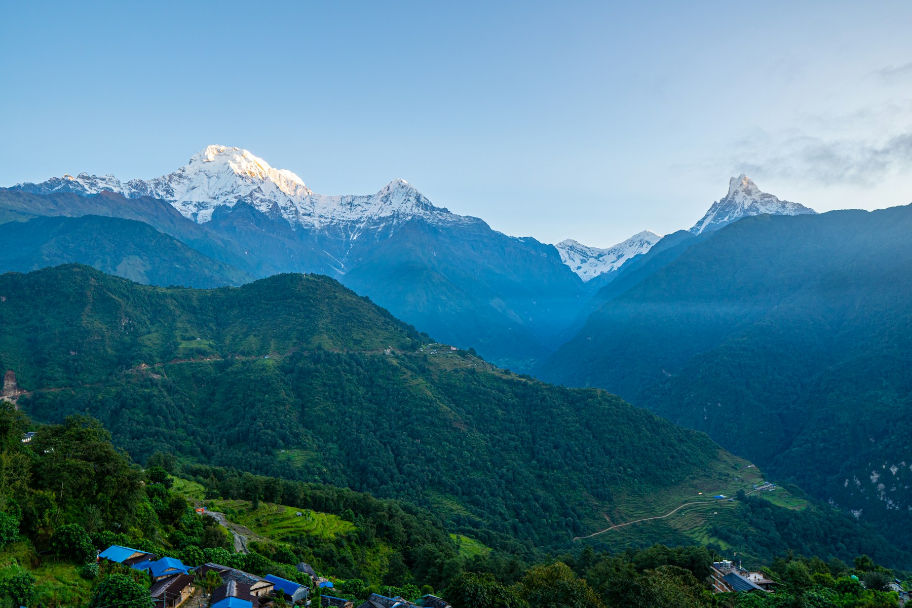 Snow-capped Himalayan peaks above a green valley in Pokhara, Nepal